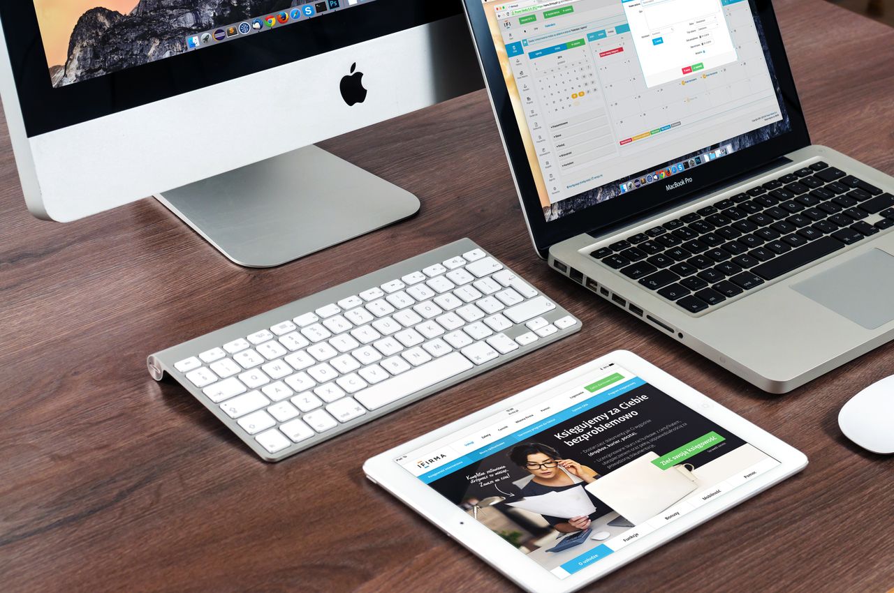 Un bureau élégant et épuré équipé d’appareils Apple : iMac, MacBook et iPad.